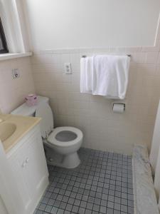 a bathroom with a white toilet and a sink at Filmores Hotel in Toronto