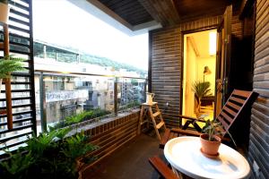 einen Balkon mit einem Tisch und einem Fenster mit Pflanzen in der Unterkunft Lienmei 月租房 in Taipeh