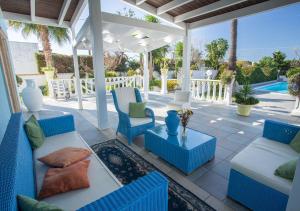 un patio con muebles azules y blancos y una piscina en Villa del Sole - Salento Mille e una Notte, en Torre Suda
