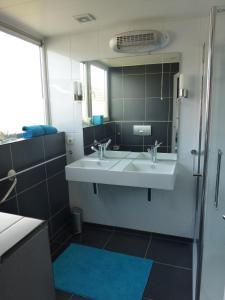 La salle de bains est pourvue d'un lavabo et d'un miroir. dans l'établissement Het Burgemeestershuis, à Barsingerhorn