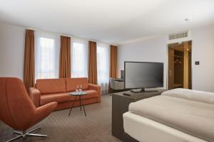 um quarto de hotel com uma cama e uma televisão em H4 Hotel Residenzschloss Bayreuth em Bayreuth