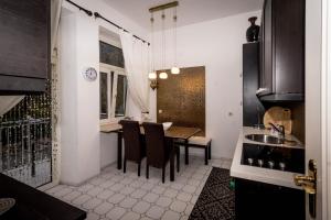 a kitchen with a table and chairs and a sink at King Luitpold Apartment in Bad Reichenhall