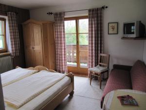 a bedroom with a bed and a tv and a chair at Haus Friedl in Kitzbühel