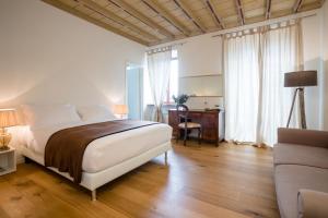 a bedroom with a bed and a desk and a couch at La Ripa Boutique Hotel in Albino