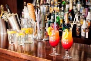 a bar with three cocktails on a wooden table at Villa Maraki in Agia Paraskevi