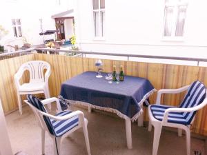 einen Tisch mit 2 Stühlen und einen Tisch mit Weinflaschen in der Unterkunft Villa Regina Maris Fewo Lachmöwe 70 m zum Strand in Bansin