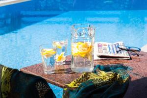 a glass of water and two glasses of water with lemon slices at Villa Maraki in Agia Paraskevi