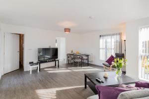 a living room with a couch and a table at Abodebed Oval View Apartments in Hemel Hempstead