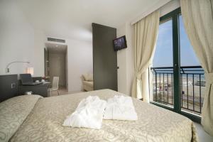 a hotel room with a bed with towels on it at Hotel Dante Family Spa Resort in Cervia