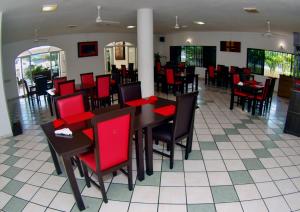 a dining room with red chairs and tables in a restaurant at Splash Inn Nuevo Vallarta & Parque Acuatico in Nuevo Vallarta