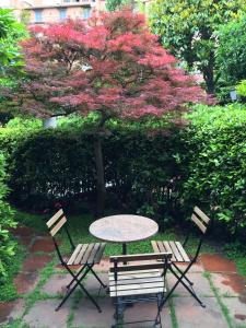 a table and two chairs and a tree with pink flowers at Forum Apartment in Rome