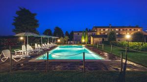 a swimming pool with chairs and a house in the background at Agriturismo Miralbello in San Lorenzo in Campo