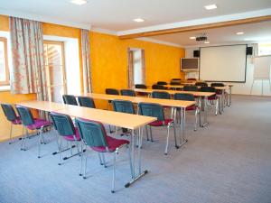 a classroom with tables and chairs and a whiteboard at Hotel Gasthof Stenitzer by Gastro4You in Haus im Ennstal