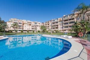 una piscina di fronte a un grande condominio di SunHome Alamos Torremolinos a Torremolinos