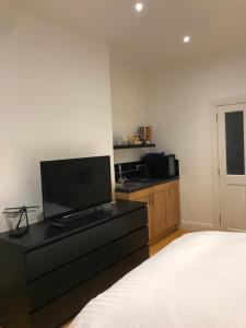 a bedroom with a bed and a flat screen tv at The Harbour Studio in Portrush