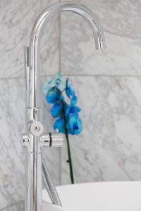 lavabo con grifo y flor azul en Ateliers de Montmartre ADM, en París