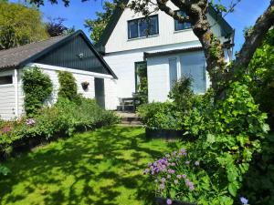 a white house with a yard with flowers at Het Burgemeestershuis in Barsingerhorn
