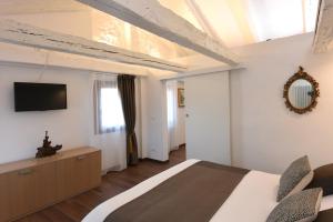 a bedroom with a bed and a tv on the wall at Sweet Apartment Frari in Venice