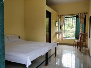 una camera ospedaliera con un letto e una finestra di Barve Homes a Ratnagiri