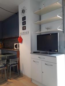 una cocina con TV en la parte superior de un armario blanco en APCOSTAS - Port Canigo, en Roses