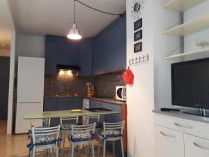 kuchnia z niebieskimi szafkami oraz stołem i krzesłami w obiekcie APCOSTAS - Port Canigo w mieście Roses