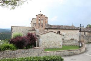 ein altes Steingebäude mit einer Kirche mit einem Turm in der Unterkunft La Pieve di San Martino in Colle di Val d’Elsa