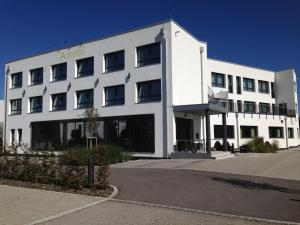 a white building with an amazon sign on it at Ammi Hotel Garni in Inning am Ammersee