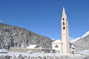 ボルミオにあるAppartamento Bormio centroの雪の塔のある教会