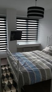 a bedroom with a bed and two windows with blinds at WHITE CITY 2 in Belgrade