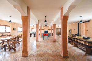una grande stanza con tavoli e panche in legno di Agriturismo Miralbello a San Lorenzo in Campo