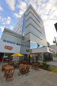 a building with tables and chairs in front of it at Hotel Panorama Economic in Ipatinga