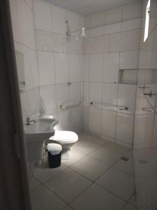 a bathroom with a toilet and a sink at Arahra Hotel in Aparecida de Goiania