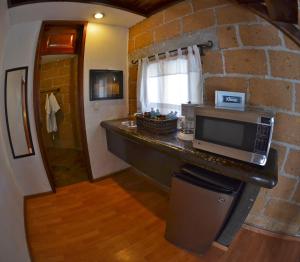 uma cozinha com um micro-ondas e uma parede de pedra em La Aldea Hotel & Spa em Atlixco