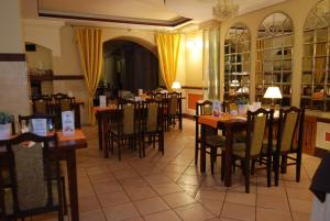 a dining room with tables and chairs in a restaurant at Hotel La-Musica in Piaseczno