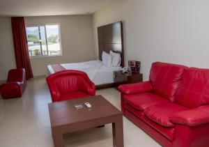 ein Wohnzimmer mit einer roten Couch und einem Bett in der Unterkunft La Isla Auto Hotel in Tuxtla Gutiérrez + 11 Fotos