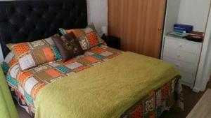 a bedroom with a large bed with a yellow quilt at Santa Margarita Coquimbo in Coquimbo