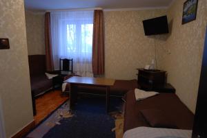 Habitación de hotel con sofá y mesa en Hotel La-Musica, en Piaseczno