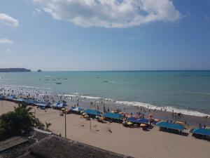 a beach with many umbrellas and crowds of people at Hotel Rosmarg in Atacames