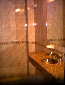 y baño con lavabo y ducha. en Hotel Paris en General San Martín