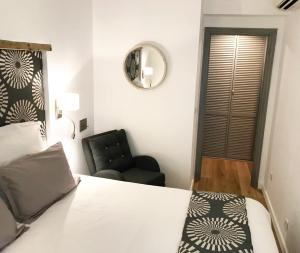 アンティーブにあるAppart' Vieil Antibesのベッドルーム1室(ベッド1台、黒い椅子付)