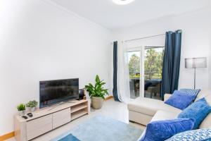 un soggiorno con divano e TV a schermo piatto di Apartamento em Quinta da Barracuda ad Albufeira