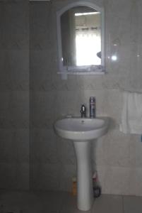 a bathroom with a white sink and a mirror at Hann Mariste in Dakar