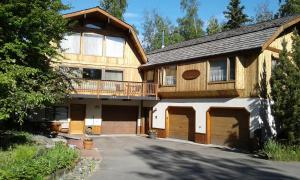 a large wooden house with two garage doors at Alaska Chalet Bed & Breakfast in Eagle River