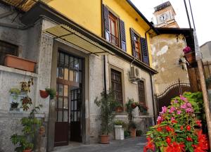 a building with flowers and a clock tower in the background at La Casa del Pescatore in Sarnico