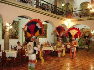 dos grupos de personas de pie en un restaurante con gente numerosa en Hotel Monte Alban - Solo Adultos, en Oaxaca City