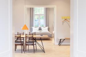 ein Esszimmer mit einem Tisch, Stühlen und einem Bett in der Unterkunft OSTKÜSTE - Villa Staudt Design Apartments in Heringsdorf