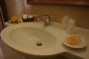 a white bathroom sink with a soap dispenser on it at Hotel Centro di Spiritualità Padre Pio in San Giovanni Rotondo