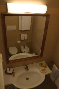a bathroom with a sink and a large mirror at Hotel Centro di Spiritualità Padre Pio in San Giovanni Rotondo