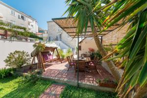 a patio with a table and chairs in a backyard at Apartments Miljas 2 in Dubrovnik