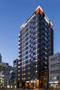 東京的住宿－飯田橋駅南APA酒店，一座建筑上标有希尔顿酒店标志